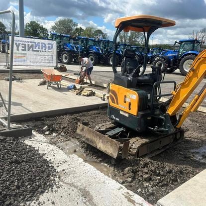 Mini digger preparing a driveway foundation