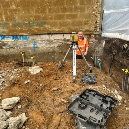 Engineer using a level on a new building foundation