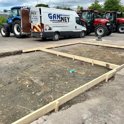Ganney groundworks yard with vans, tractors and a new concrete slab